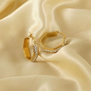 Elegant geometric hexagonal gold hoop earrings with sparkling crystal accents on silk