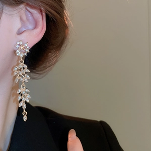 Détail de boucles d'oreilles pampilles épi de blé serties de cristaux portées par le mannequin