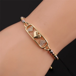 Macro detail of tricolor beads and gold-plated heart pendant with pave cubic zirconia