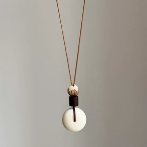 Collier pendentif de style ethnique avec perles en céramique et sculpture de lotus