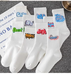 Detail of white cotton athletic crew socks featuring colorful street graffiti print