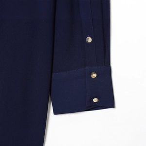 Manche de robe courte bleu marine avec trois boutons dorés décoratifs sur tissu chic