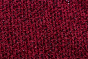 Vue macro de la texture du tissu en tweed rouge et noir et des fibres de maille tissées