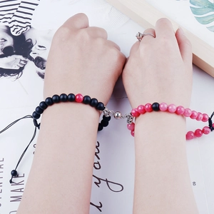 Close-up of couples wearing magnetic stone bead bracelets showing the heart connection