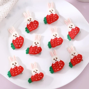 Detailed embroidery of rabbit and carrot hair clips on a white ceramic plate