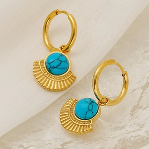 Bohemian gold turquoise fan earrings on elegant white fabric background with soft lighting