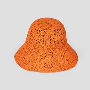 Detail of bright orange crochet straw hat featuring intricate hollow flower patterns