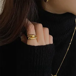 Polished gold irregular fluid ring shown on hand with minimalist aesthetic