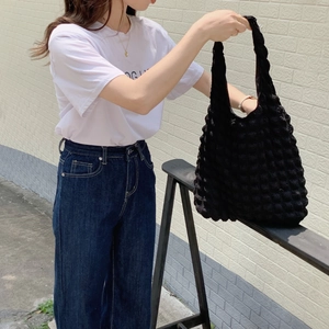 Detailed macro view showing the textured bubble knit fabric of this black tote bag