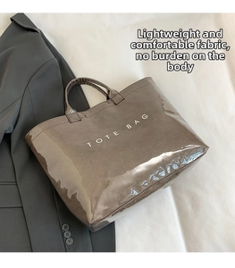 Close-up of gloss finish tote bag showing the reflective material and white text