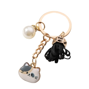 Cute cat charm keychain with white pearl and black tassel in a polished gold finish