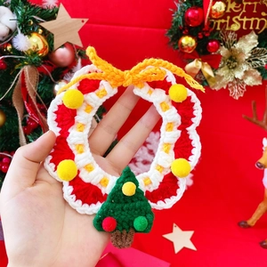 Macro shot of hand-knitted Christmas pet wreath collar with red and green yarn