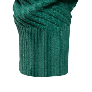 Detailed close-up of green knit sweater showing ribbed cuff and cable stitch texture
