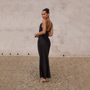 Detail of black satin maxi dress showing the low back cut and slim fit silhouette