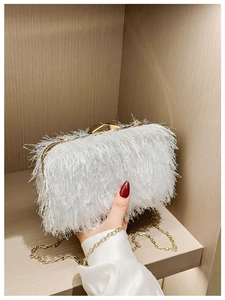 Detailed macro view of a white fringe evening bag with gold metal frame and clasp
