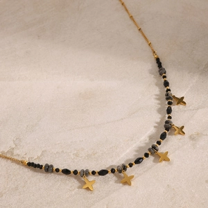 Detail of gold-plated stainless steel necklace with grey beads and five star charms