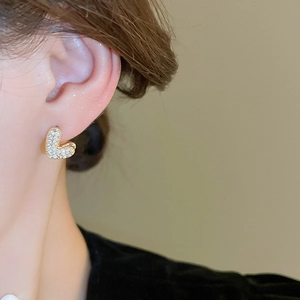 Gros plan sur des boucles d'oreilles en cœur plaqué or avec pavé de zircone blanc