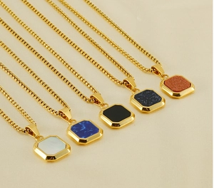Detail of square gold pendants with natural sandstone and marble stone inlays