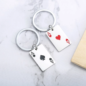 Detailed view of silver metal Ace of Hearts and Ace of Spades poker card keychains