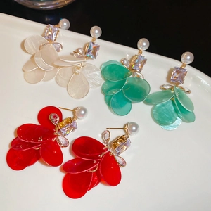 Detailed view of cubic zirconia flower petal earrings in white, green, and red colors