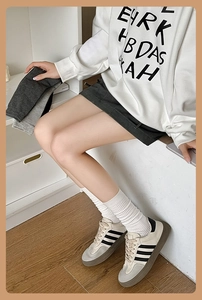 Close-up of white ribbed crew socks with knitted texture worn with casual sneakers