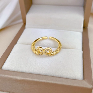 Macro shot of gold-plated infinity ring with white zircons and Ruyi pattern carvings