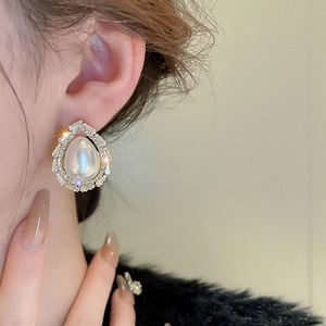 Détail de boucle d'oreille goutte avec perle large et cristaux brillants sur mannequin