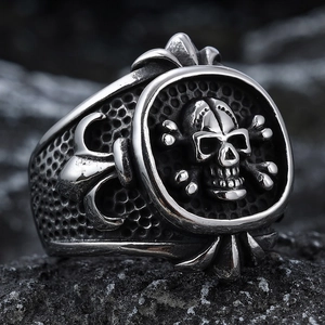 Vintage gothic skull ring for men in stainless steel with fleur-de-lis on dark rock