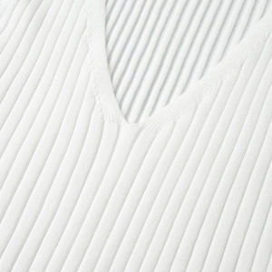 Close-up of the deep V-neckline and soft ribbed knit texture of the white dress