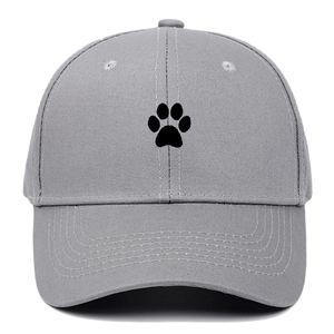 Close-up of black animal paw embroidery on grey cotton baseball cap with curved brim