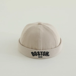 Dettaglio del cappello docker per bambini in velluto a coste beige con ricamo BOSTON nero