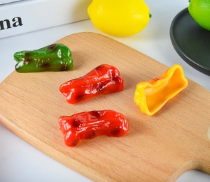 Macro view of highly realistic assorted bell pepper models on a rustic wooden board