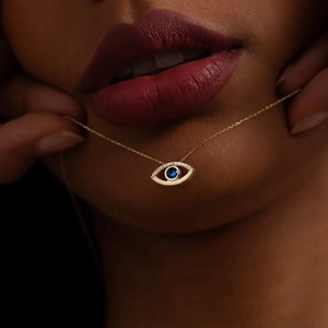 Fashionable evil eye necklace with blue stone and gold chain on elegant model