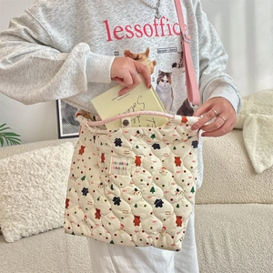 Close-up of quilted canvas shoulder bag featuring cute bear patterns and top snap closure