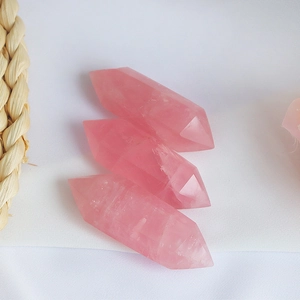 Detailed macro view of three double-pointed rose quartz hexagonal crystal pillars