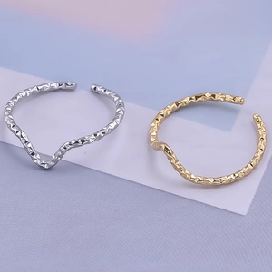 Detail of adjustable wave rings in gold and silver with textured hammered surface