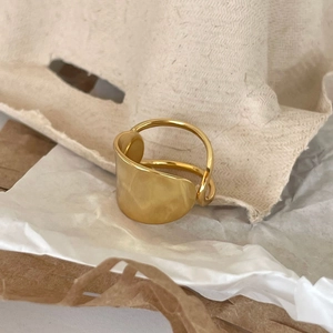 Irregular wide gold ring with a geometric curved design in a minimalist French style