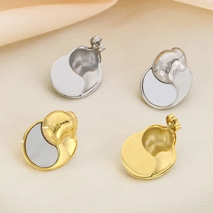 Minimalist crescent shell earrings in gold and silver finish on soft fabric