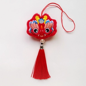 Détail macro du pendentif lion de danse chinoise rouge avec broderie et longue boucle en soie