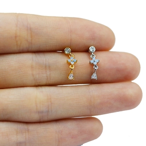 Close-up of gold and silver dangle earrings with blue opals and teardrop zircon details