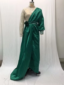 Detail of sequin embroidery on asymmetric sleeve and green satin evening gown