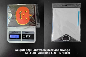 Macro shot of Halloween pumpkin flag banners on scale showing 62g weight and 13x18cm size