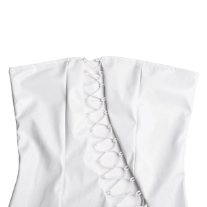 Dettaglio ravvicinato dei lacci incrociati su un abito bustier bianco in ecopelle