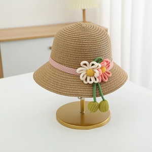 Detail of children's straw hat featuring pink polka dot ribbon and 3D fabric flowers