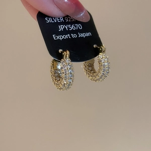 Detail of 18K gold plated U-shape earrings with cubic zirconia on black display card