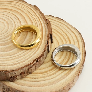 Bagues minimalistes en acier inoxydable doré 18 carats et argent sur bois