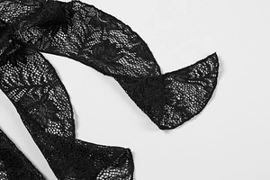 Détail de la broderie en dentelle florale noire et des bords festonnés sur la robe
