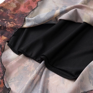 Macro detail of ruffled mesh hem with vintage print and black lining on slim dress