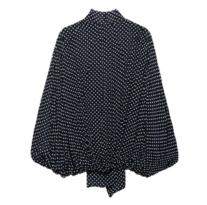 Detail of high neck black polka dot chiffon top featuring elegant puff lantern sleeves