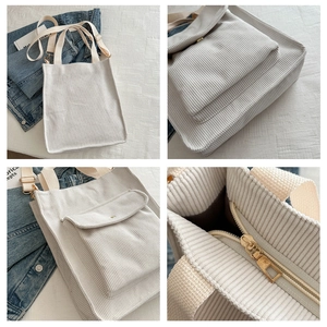 Detail view of white corduroy tote bag featuring front flap pocket and canvas straps